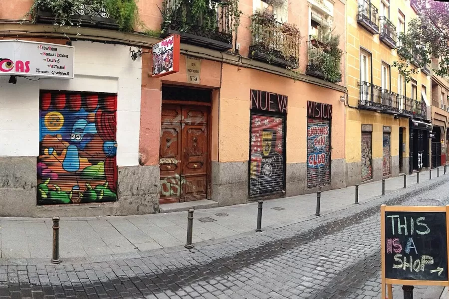 Colourful shopfronts on a narrow street in the Malasaña neighbourhood of Madrid