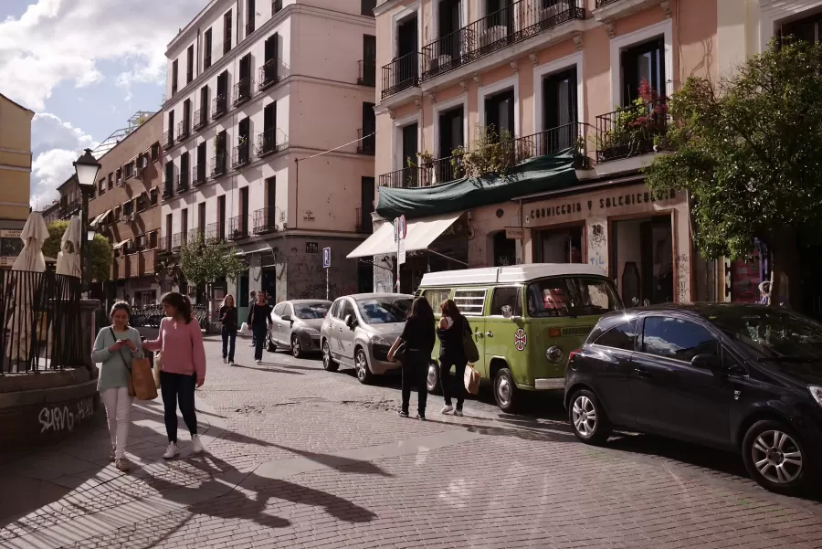 Residential street in central Madrid with balconies, cafés and parked cars