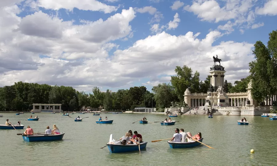 Rowing boats on the large pond in El Retiro Park, with the Alfonso XII monument behind
